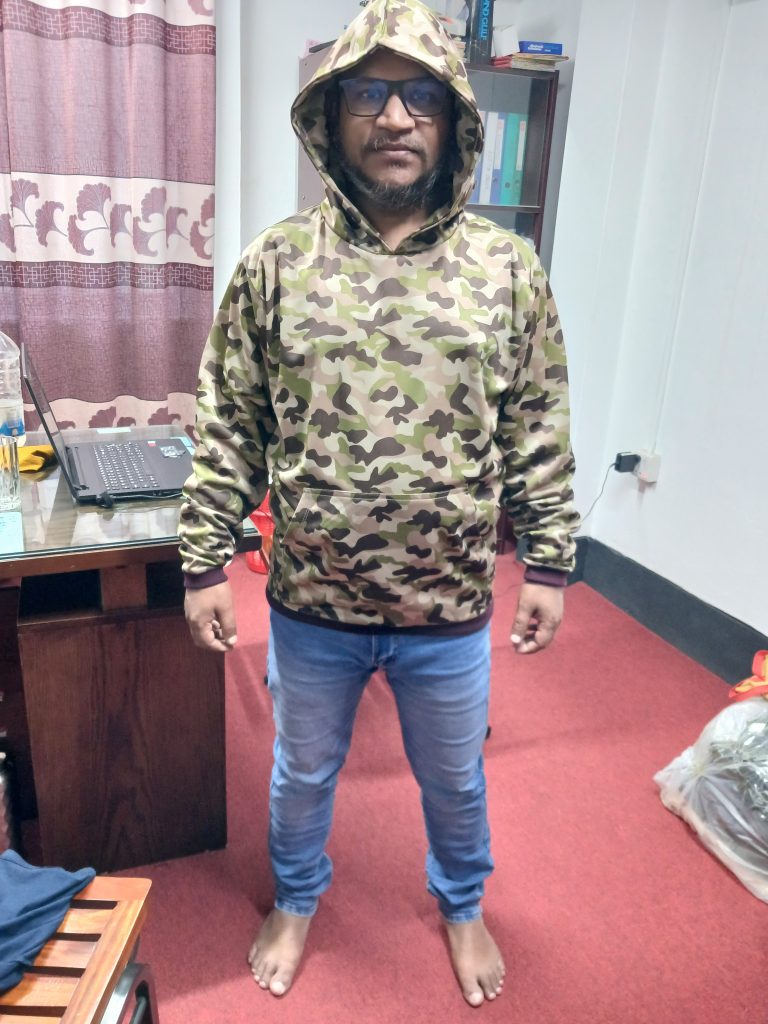 Creator wearing a military-grade Multicam camouflage hoodie outdoors, testing the durable fabric.